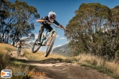 A rider floats over a tabletop jump competing in the Thredbo Super Enduro.